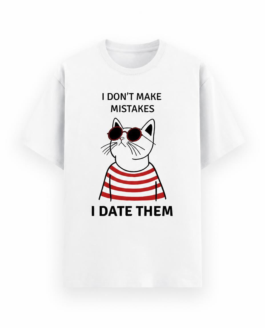 A white short-sleeve crewneck t-shirt featuring a graphic of a cartoon cat wearing red and white striped sunglasses and a red and white striped shirt, with the text 'I DON'T MAKE MISTAKES' above and 'I DATE THEM' below.