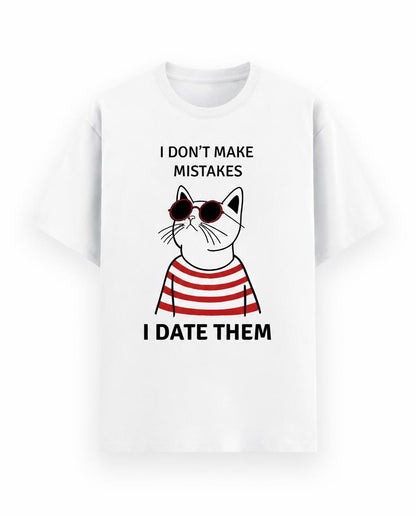 A white short-sleeve crewneck t-shirt featuring a graphic of a cartoon cat wearing red and white striped sunglasses and a red and white striped shirt, with the text 'I DON'T MAKE MISTAKES' above and 'I DATE THEM' below.