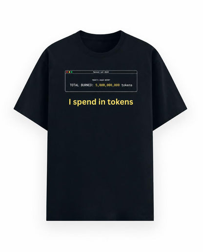 A navy blue short-sleeve t-shirt with a graphic print on the chest. The graphic features a computer window with white text reading 'TOTAL BURNED: 5,000,000,000 tokens' and the phrase 'I spend in tokens' printed below in yellow.