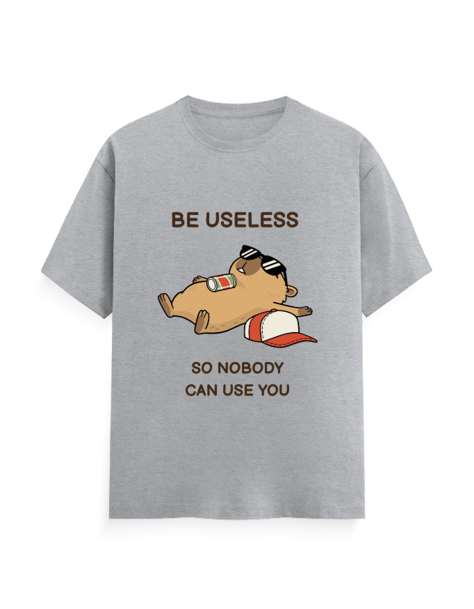 A heather gray short-sleeve t-shirt with a cartoon graphic of a brown hamster wearing sunglasses and a red-and-white cap, with the text 'BE USELESS SO NOBODY CAN USE YOU' printed on the front.