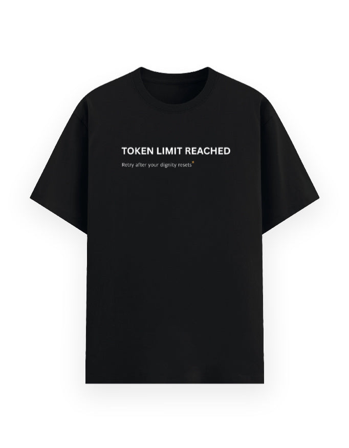 A black short-sleeve crewneck t-shirt with white printed text on the chest reading 'TOKEN LIMIT REACHED' and Retry after your dignity resets, displayed against a solid white background.