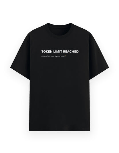 A black short-sleeve crewneck t-shirt with white printed text on the chest reading 'TOKEN LIMIT REACHED' and Retry after your dignity resets, displayed against a solid white background.